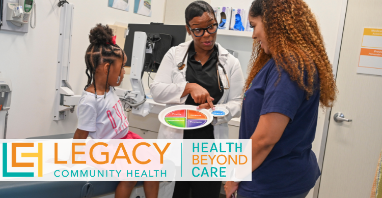 Legacy Community Health clinician shows a color-coded care chart to an adult patient while a child sits on an exam table in a clinic room, illustrating coordinated, patient-centered care.
