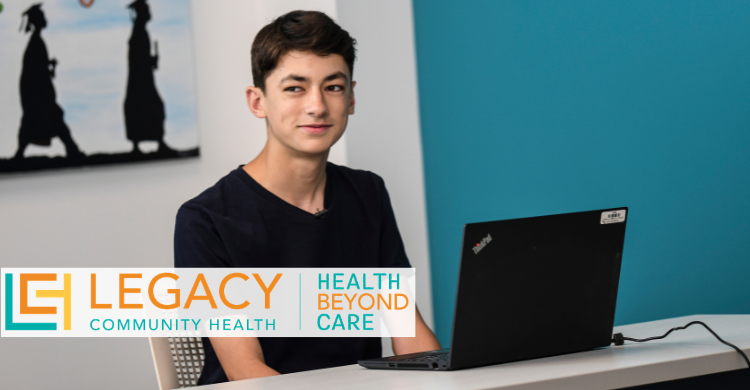Young man sits at a desk with an open laptop, a Legacy Community Health banner in front.