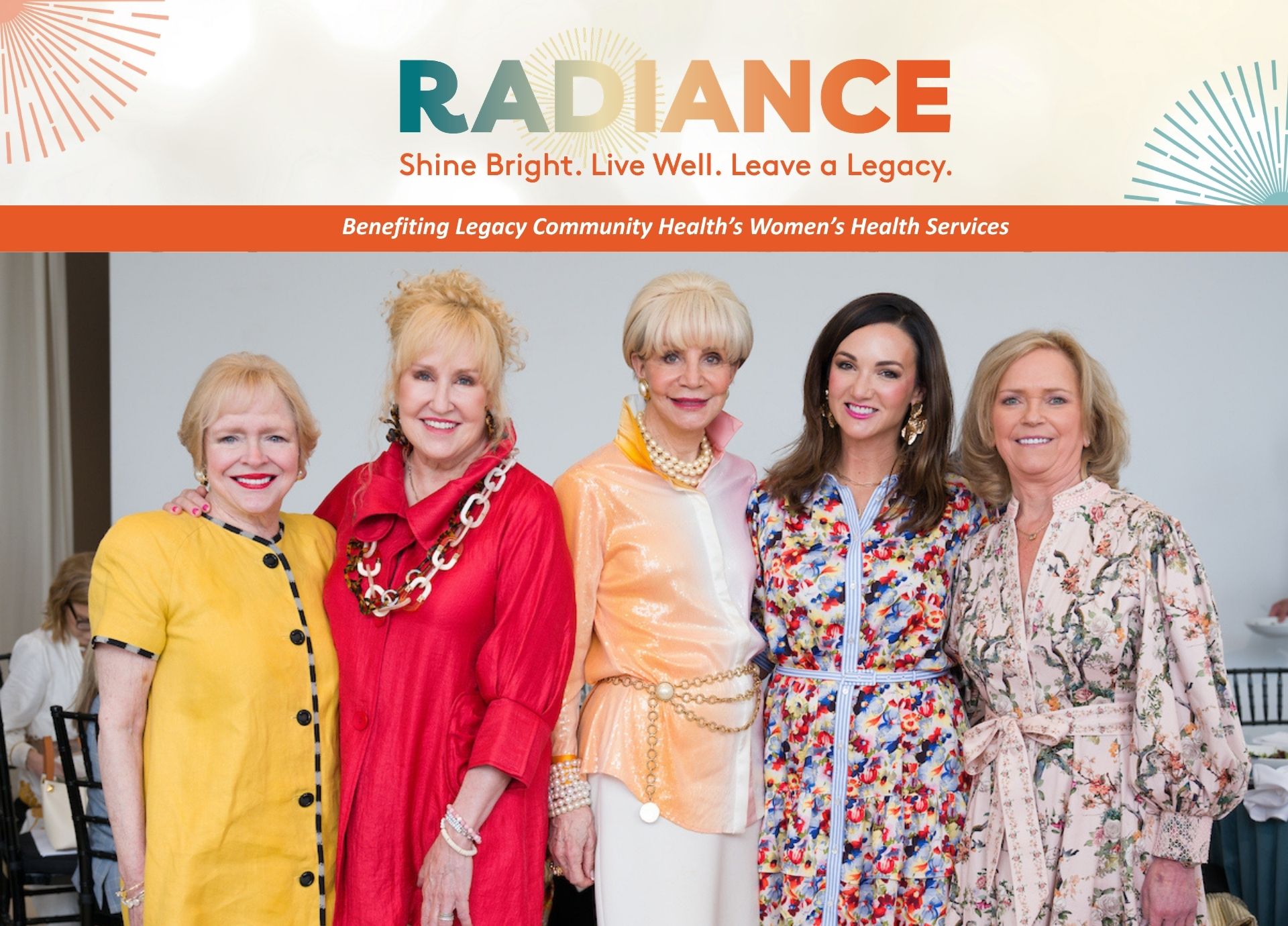 Five attendees pose together at the Radiance luncheon benefiting Legacy Community Health’s women’s health services, standing side by side and smiling in colorful floral and bright-toned outfits beneath event branding that reads “Radiance: Shine Bright. Live Well. Leave a Legacy.”