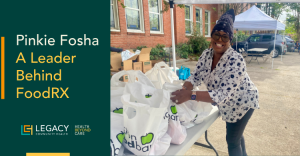 Smiling woman in a patterned top arranges white FoodRX bags on a table at an outdoor food drive; left teal panel reads 'Pinkie Fosha: A Leader Behind FoodRX' with Legacy Health logos.
